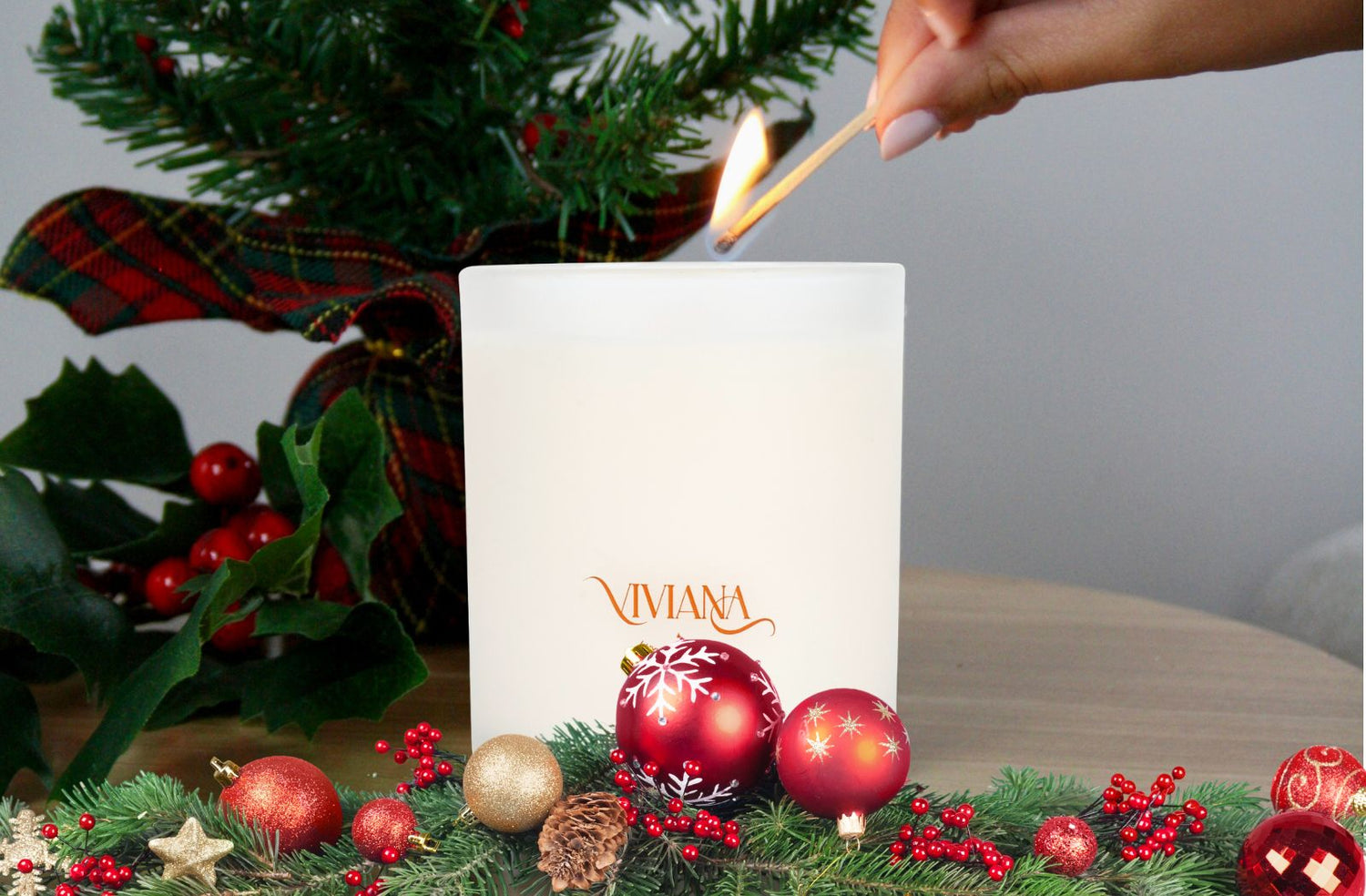 Best holiday candle next to a Christmas tree and holiday decorations