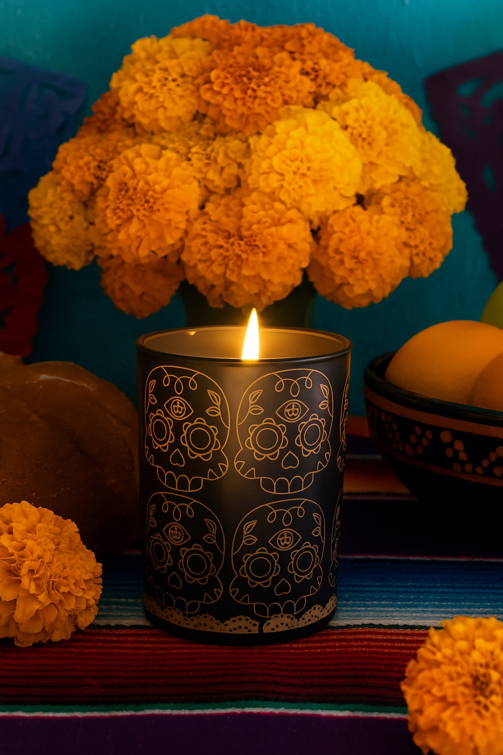 Día de los Muertos eggplant glass candle with silk-screen calavera artwork styled with marigolds, by Viviana Luxury.