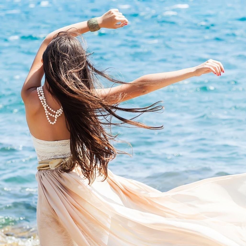 Beach candle captures the freedom of a beautiful woman on the beach and ocean.