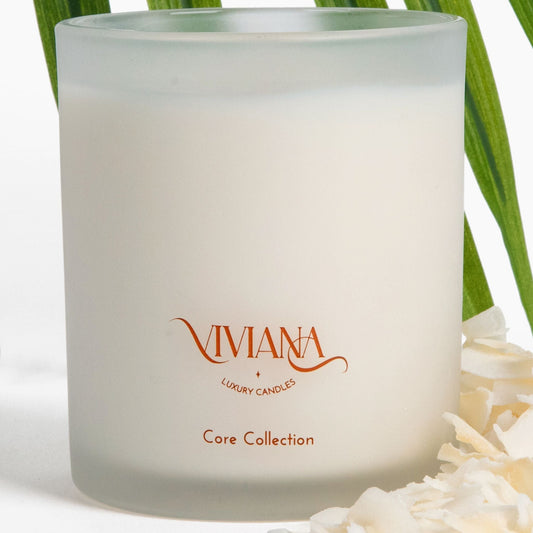 Coconut candle with coconut flakes and palm leaves.