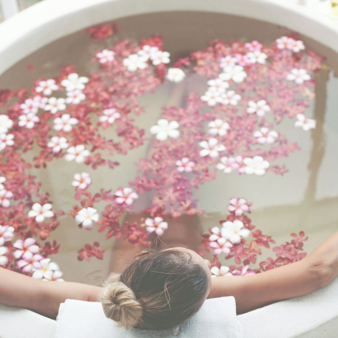 Hibiscus flower candle and bath with beautiful woman relaxing.